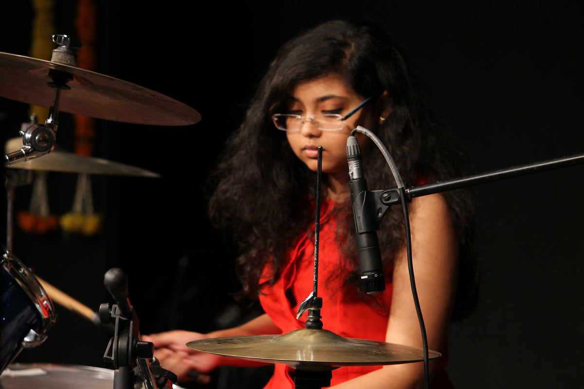 Female drummer performing on an acoustic drum kit at Aurzart Music Academy in Bangalore